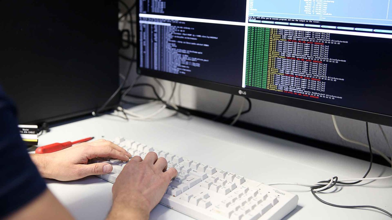 Perspektiven im Bereich Cybercrime bei der Polizei Sachsen: Ein Mitarbeiter sitzt an einem PC-Arbeitsplatz mit mehreren Monitoren.
