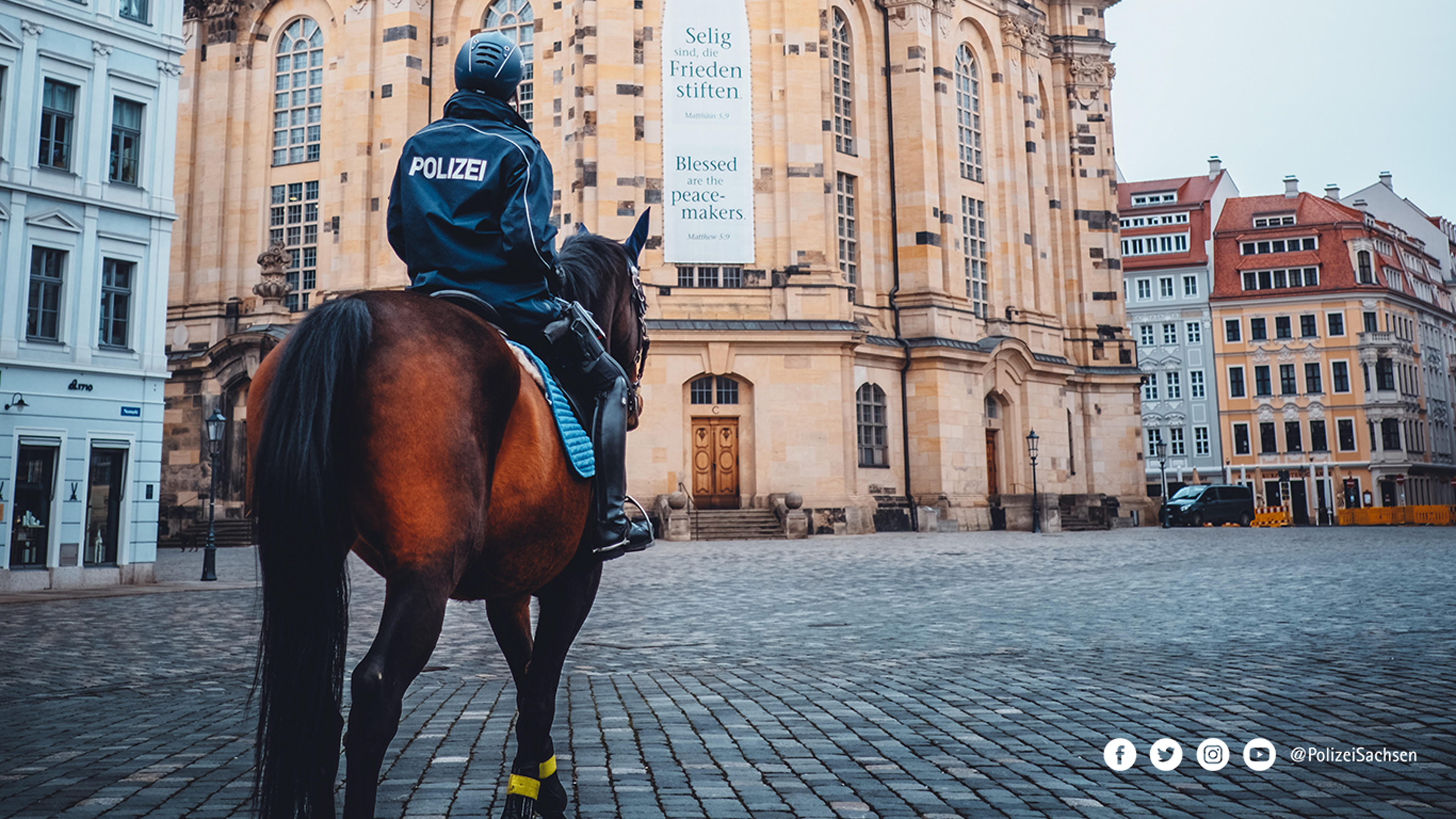 Eine Polizeireiterin auf einem Dienstpferd vor der Frauenkirche in Dresden.